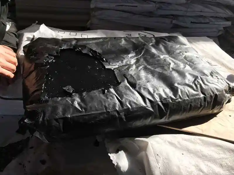 Oxidized Bitumen 150/5 block partially unwrapped from its packaging at ATDM facility.