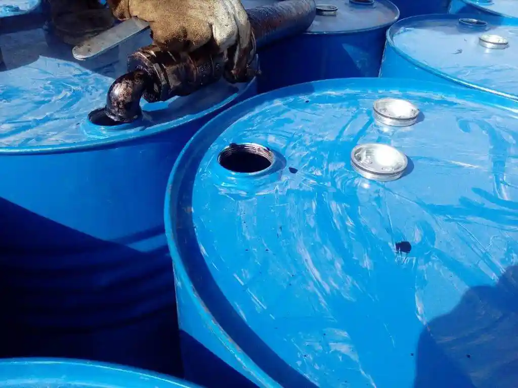 Bitumen SC30 being filled into blue steel drums during production at ATDM facility.