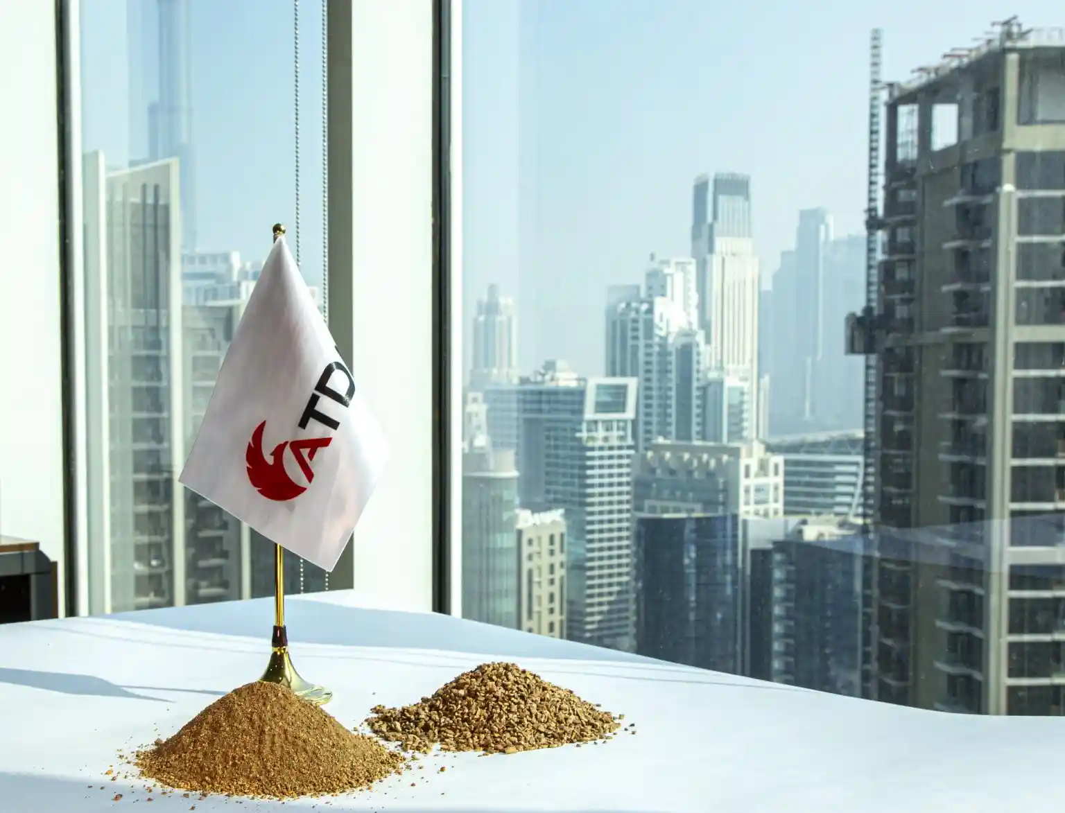 Walnut shell granules and powder for drilling fluid loss control supplied by ATDM, displayed with company flag and city skyline background.